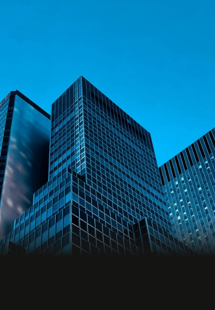 Modern glass towers against a bright blue sky